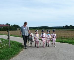 Ein Pony wird ausgeführt und Kinder begleiten es